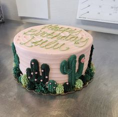 a birthday cake decorated with green and pink frosting