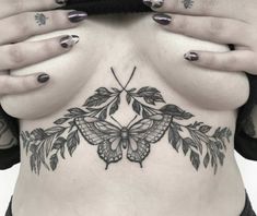 a woman with tattoos on her stomach holding her hands to her chest