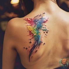 the back of a woman's shoulder with colorful paint splattered on it