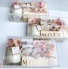 three clear boxes filled with candles and flowers