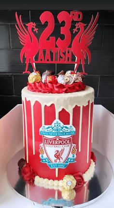 there is a red cake with white frosting on the top that has liverpool's crest