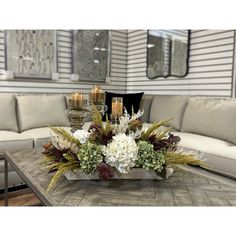 a living room filled with lots of furniture and flowers on top of a coffee table