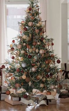 a decorated christmas tree in a living room with presents on the floor next to it