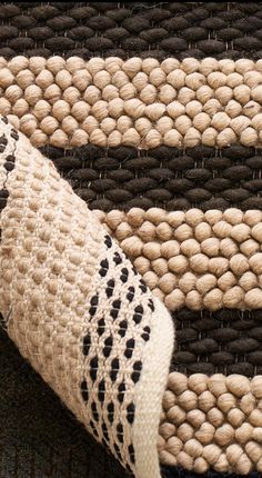 a close up view of a rug with black and white designs on it, including an animal's tail