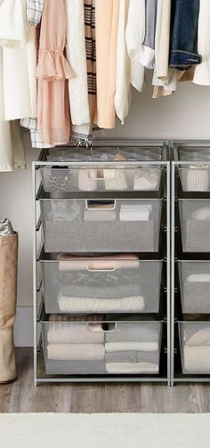 an organized closet with clothes hanging on the rack and folded towels in bins next to it