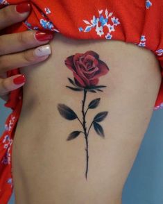 a woman's stomach with a rose tattoo on it