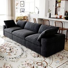 a black couch sitting on top of a rug in a living room