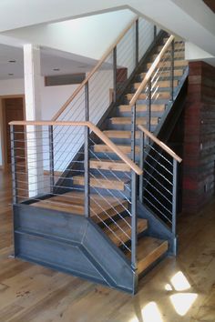 a metal stair case with wooden handrails