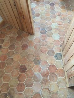 a tiled floor with wooden slats on the sides and an open door in the middle