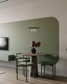 a dining room table with chairs and a television mounted on the wall in front of it