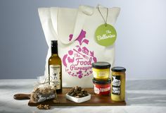 an assortment of food and condiments sitting on a wooden tray next to a bag