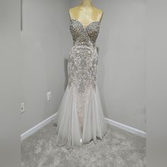 a dress on display in a room with gray carpet and white walls, along with a yellow mannequin