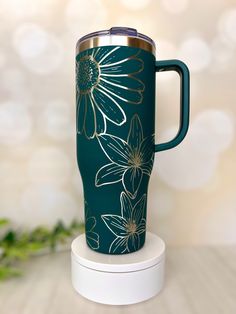 a green coffee cup with white flowers on it