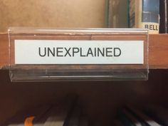 an unexplained sign on a shelf in a library