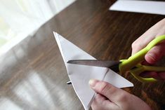 a person cutting paper with scissors on a table