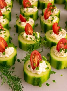 cucumber slices with tomatoes and cream cheese on them