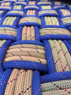 a close up view of some blue and yellow braided rope with red dots on it