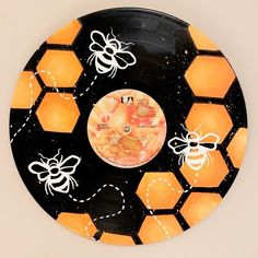 a black and orange plate with bees on it's side, surrounded by honeycombs