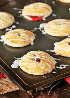 freshly baked pastries with icing on a baking sheet