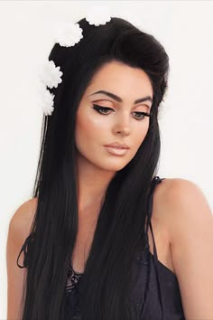 Jackie Wyers wears a black wig with lots of volume decorated with white large flowers across the crown. She is looking down showing the makeup consisting of a light peach lid, cut crease dramatic eyeliner, full lashes, tanned skin and a frosty nude lip with a deeper lip liner. Priscilla Presley Hair, 60s Makeup Tutorial, 70s Inspired Makeup, Priscilla Presley Wedding, Presley Wedding, 60’s Makeup, Jackie Wyers, 60s Makeup