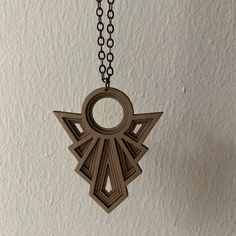 a wooden necklace with an ornament hanging from it's side on a chain