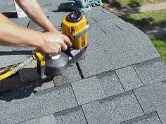 a man using a power tool on top of a roof