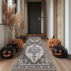 a hallway decorated for halloween with pumpkins on the floor and an area rug in front of it