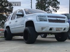 a white truck parked next to another blue car