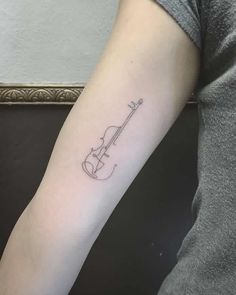 a person with a violin tattoo on their arm