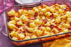 a casserole dish with potatoes and meat in it on a purple table cloth