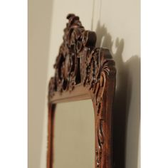 an ornate wooden mirror hanging on the wall