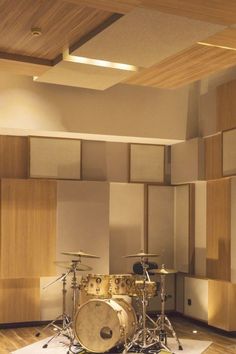 a drum set sitting on top of a hard wood floor in front of a wall