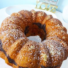 a bundt cake sitting on top of a white plate covered in powdered sugar