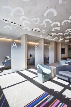 an office lobby with couches, chairs and mirrors on the walls that reflect light