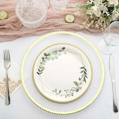 a table setting with plates, silverware and flowers