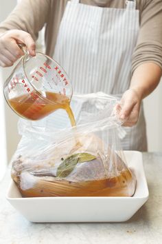 a person pouring something into a bag on top of a white plate with food in it