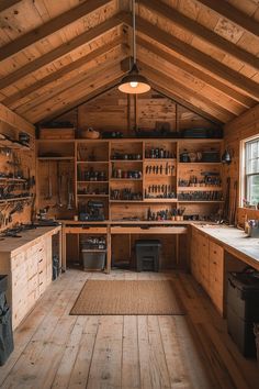 the inside of a wood cabin with lots of work tools on shelves and wooden flooring