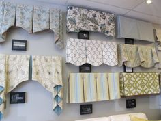 the wall is covered with many different types of curtains and valances on display