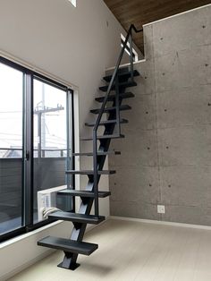 an empty room with a stair case next to a window