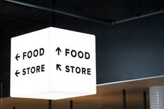 a white light hanging from the ceiling with food and store signs on it's sides