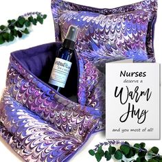 a bottle of lavender sits on top of a purple and white pillow next to a sign that says nurses deserves a warm hug