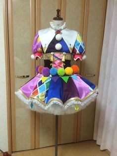 a mannequin dressed in colorful clothing with pom poms