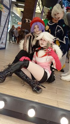 two cosplays sitting on the ground in front of a mirror