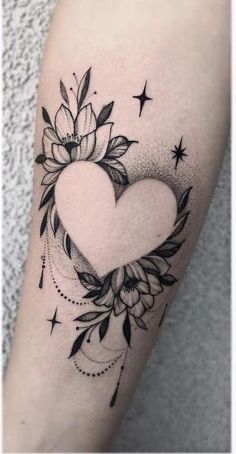 a black and white heart tattoo with flowers on the side of the arm, surrounded by stars