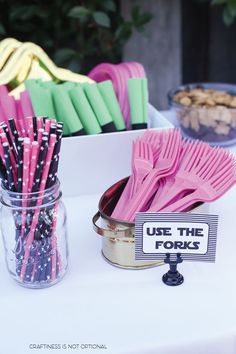 there are many pink and green straws in the tin on the table next to each other