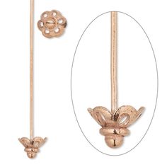 a pair of gold colored metal hooks with flowers on each end and an oval hole in the middle