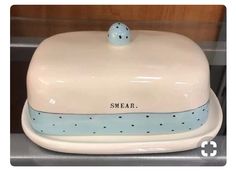 a white and blue cake dish with a small bird on it's top that says smeaar