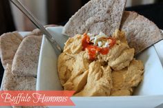 a white bowl filled with hummus and tortilla chips