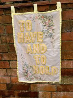 a banner hanging on a brick wall that says to have and to hold