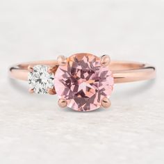 a pink and white diamond ring with two diamonds